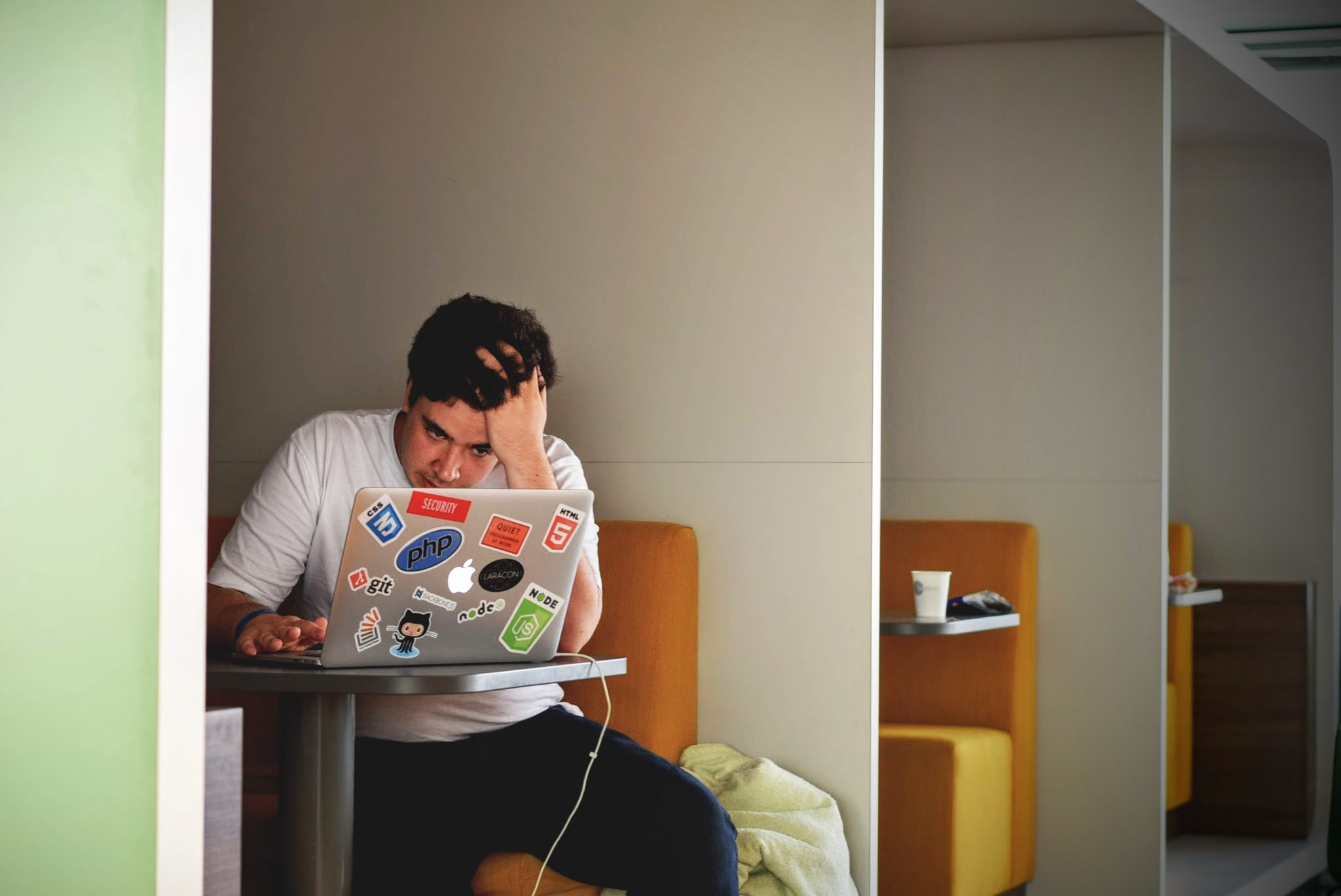 A man looking confused and frustrated at a laptop