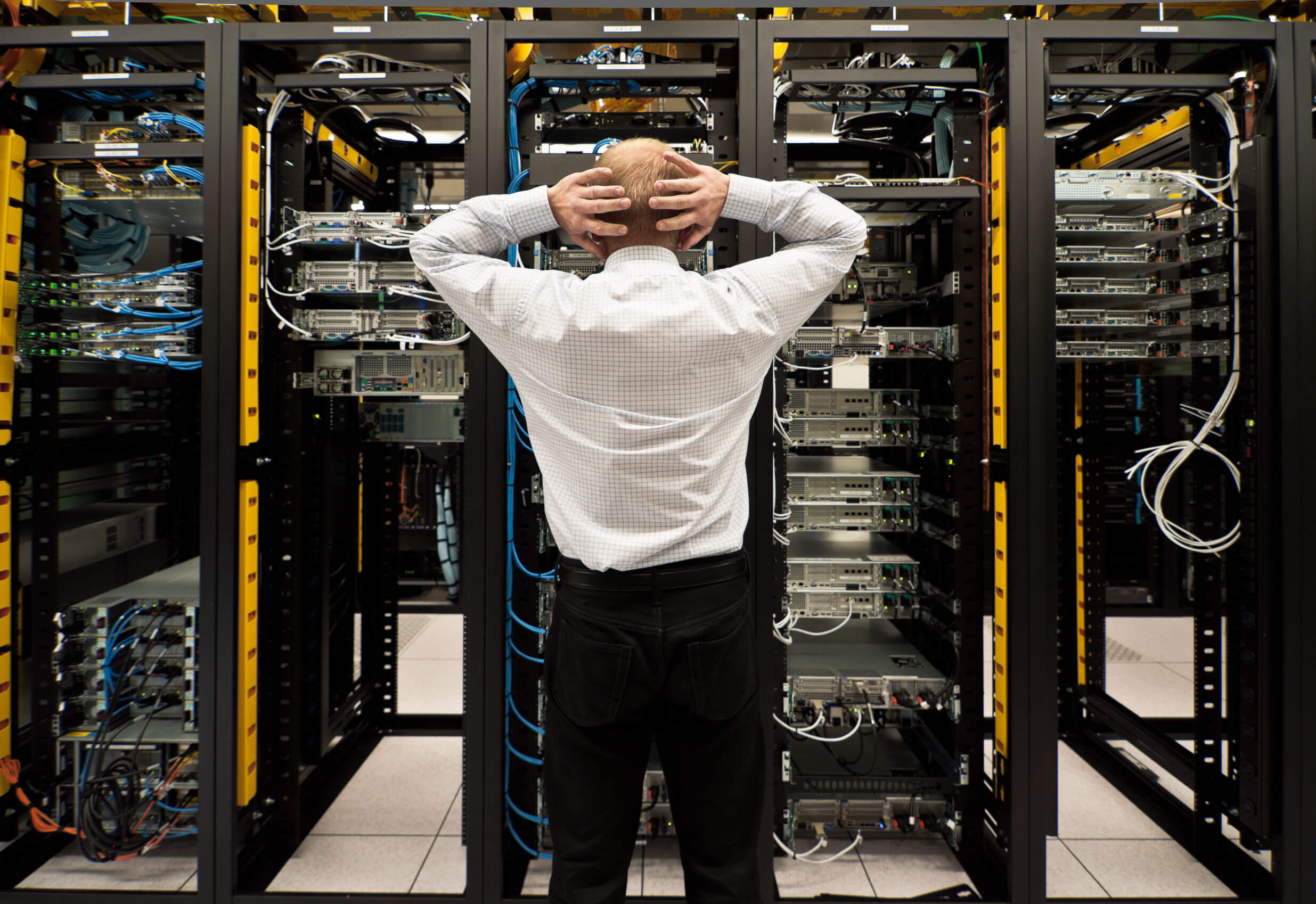 A man staring at a rack of servers
